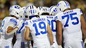 Sep 27, 2025; Boulder, Colorado, USA; Members of the Brigham Young Cougars offensive squad huddle in the second quarter against the Colorado Buffaloes at Folsom Field. Mandatory Credit: Ron Chenoy-Imagn Images