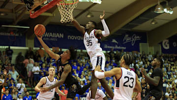 Nov 25, 2024; Lahaina, Hawaii, USA; Memphis Tigers guard PJ Haggerty (4) tries for the basket while being guarded by Connecticut Huskies center Samson Johnson (35)  in the second half of an NCAA college basketball game at Lahaina Civic Center. Mandatory Credit: Marco Garcia-Imagn Images