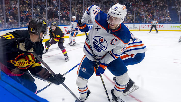 Edmonton Oilers forward Connor McDavid (97) battles with Vancouver Canucks defenseman Erik Brannstrom (26)