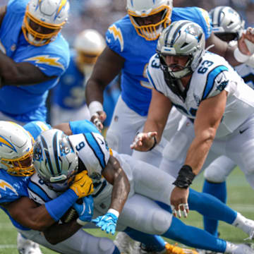 Sep 15, 2024; Charlotte, North Carolina, USA; Carolina Panthers running back Miles Sanders (6) is tackled by Los Angeles Chargers linebacker Daiyan Henley (0) during the second half at Bank of America Stadium. Mandatory Credit: Jim Dedmon-Imagn Images