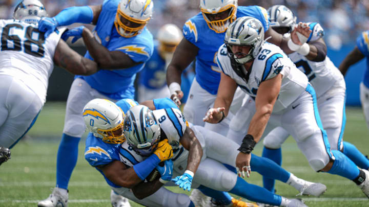 Sep 15, 2024; Charlotte, North Carolina, USA; Carolina Panthers running back Miles Sanders (6) is tackled by Los Angeles Chargers linebacker Daiyan Henley (0) during the second half at Bank of America Stadium. Mandatory Credit: Jim Dedmon-Imagn Images