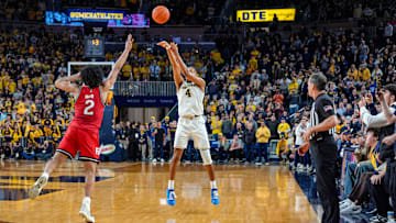 Michigan Wolverines guard Nimari Burnett (4) shoots the game-winning 3-pointer over Rutgers Scarlet Knights guard Dylan Harper (2) during the second half at Crisler Center in Ann Arbor on Thursday, Feb. 27, 2025.