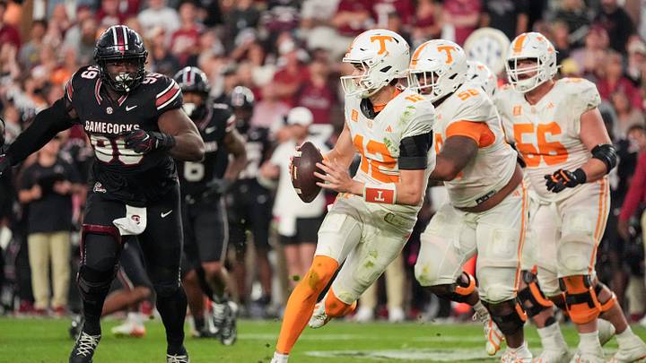 Oct 24, 2026; Columbia, South Carolina, USA;  Tennessee Volunteers quarterback George MacIntyre (12) scrambles against South Carolina Gamecocks defensive lineman Gabriel Brownlow-Dindy (99) during the second half at Williams-Brice Stadium.  Mandatory Credit: Jim Dedmon-Imagn Images