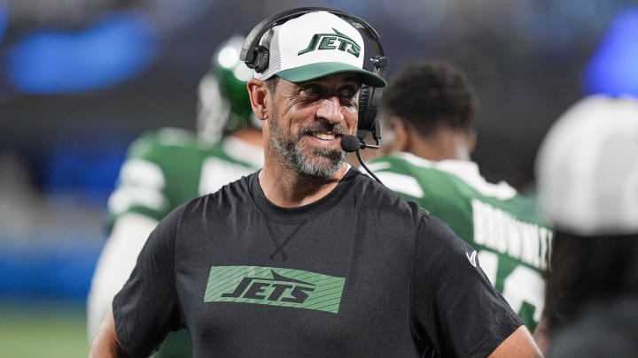 Aug 17, 2024; Charlotte, North Carolina, USA; New York Jets quarterback Aaron Rodgers (8) shares a laugh on the sidelines during the second half against the Carolina Panthers at Bank of America Stadium.