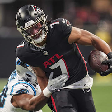 Jan 5, 2025; Atlanta, Georgia, USA; Atlanta Falcons running back Bijan Robinson (7) runs against Carolina Panthers linebacker D.J. Wonnum (98) during the first quarter at Mercedes-Benz Stadium. Mandatory Credit: Dale Zanine-Imagn Images