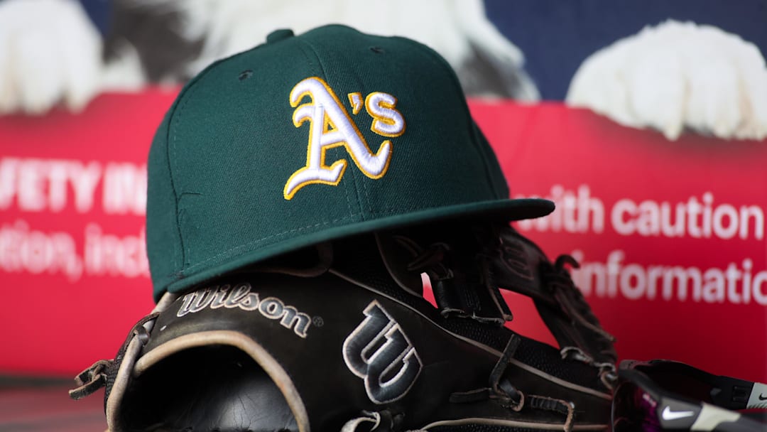 Jun 1, 2024; Atlanta, Georgia, USA; A detailed view of an Oakland Athletics hat and glove on the field against the Atlanta Braves in the sixth inning at Truist Park. Mandatory Credit: Brett Davis-Imagn Images