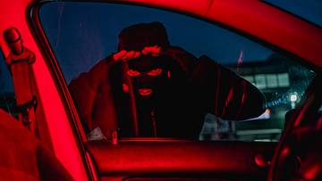Car thief looking through car window