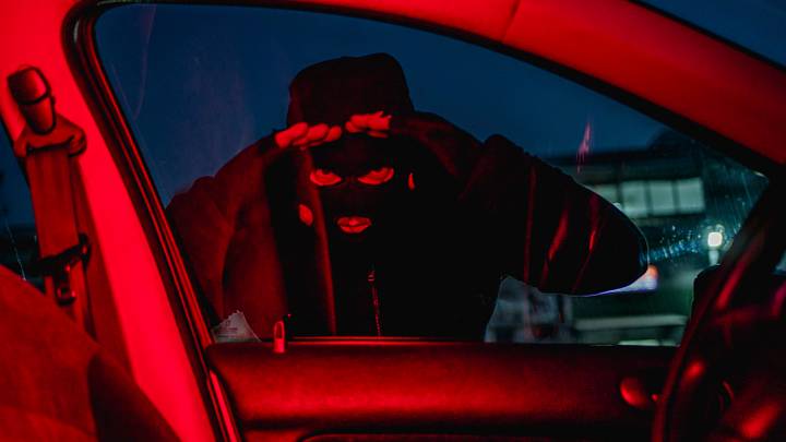 Car thief looking through car window