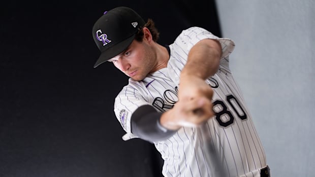 Colorado Rockies infielder Kyle Karros swings a bat while wearing a white uniform with black pinstripes and a black hat