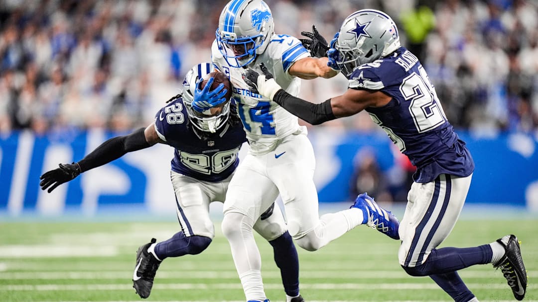 Dec 4, 2025; Detroit, Michigan, USA; Detroit Lions wide receiver Amon-Ra St. Brown (14) makes a catch against Dallas Cowboys safety Malik Hooker (28) and cornerback DaRon Bland (26) during the first half at Ford Field. Mandatory Credit: Junfu Han-USA TODAY Network via Imagn Images