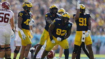 Dec 31, 2024; Tampa, FL, USA;  Alabama Crimson Tide quarterback Jalen Milroe (4) is sacked by Michigan Wolverines defensive lineman Ike Iwunnah (92) in the third quarter during the ReliaQuest Bowl at Raymond James Stadium. Mandatory Credit: Nathan Ray Seebeck-Imagn Images