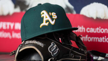 Jun 1, 2024; Atlanta, Georgia, USA; A detailed view of an Oakland Athletics hat and glove on the field against the Atlanta Braves in the sixth inning at Truist Park. Mandatory Credit: Brett Davis-USA TODAY Sports