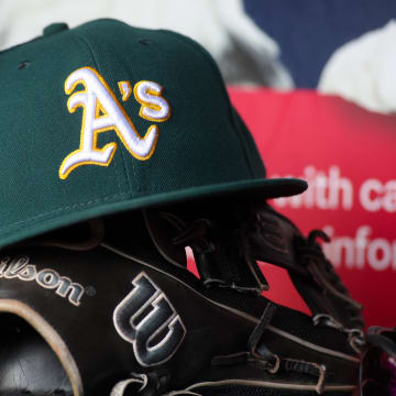 Jun 1, 2024; Atlanta, Georgia, USA; A detailed view of an Oakland Athletics hat and glove on the field against the Atlanta Braves in the sixth inning at Truist Park. Mandatory Credit: Brett Davis-USA TODAY Sports