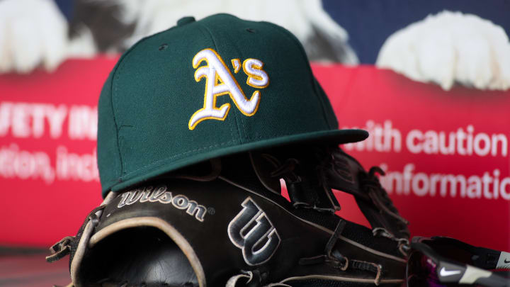 Jun 1, 2024; Atlanta, Georgia, USA; A detailed view of an Oakland Athletics hat and glove on the field against the Atlanta Braves in the sixth inning at Truist Park. Mandatory Credit: Brett Davis-USA TODAY Sports