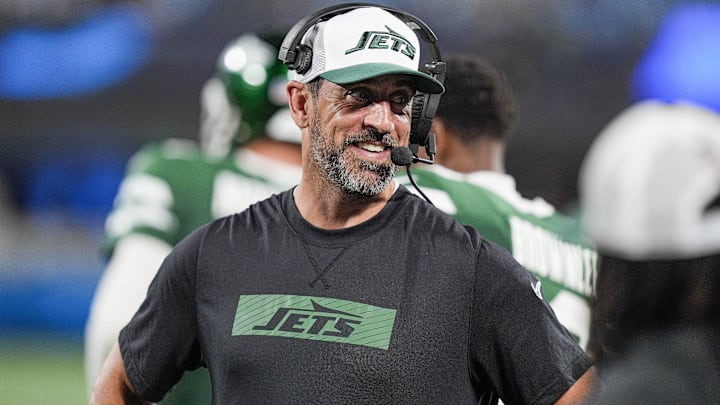 Aug 17, 2024; Charlotte, North Carolina, USA;  New York Jets quarterback Aaron Rodgers (8) shares a laugh on the sidelines during the second half against the Carolina Panthers at Bank of America Stadium.