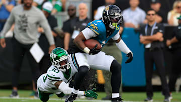 Jacksonville Jaguars running back Travis Etienne Jr. (1) rushes for yards against New York Jets cornerback Michael Carter II (30) during the second quarter Sunday, Dec. 15, 2024 at EverBank Stadium in Jacksonville, Fla. [Corey Perrine/Florida Times-Union]