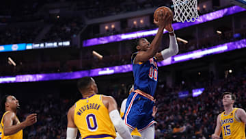 Feb 12, 2022; San Francisco, California, USA; Golden State Warriors forward Jonathan Kuminga (00) scores in front of Los Angeles Lakers guard Russell Westbrook (0) in the second quarter at the Chase Center. Mandatory Credit: Cary Edmondson-Imagn Images