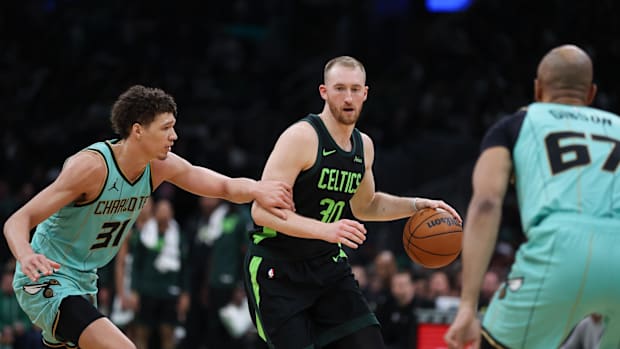 The Boston Celtics striker Sam Hauser (30) Dribbles on the ground defended by Charlotte Hornets Fordjane Salaun (31)
