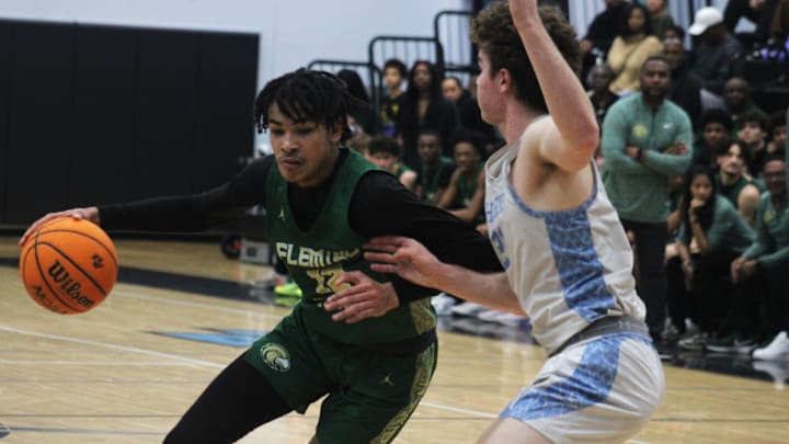 Fleming Island forward Carson Crawford (12) dribbles into the lane as Ponte Vedra forward Tyler Cowan (21) defends during an FHSAA District 3-6A high school boys basketball semifinal on February 8, 2024. [Clayton Freeman/Florida Times-Union]