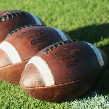 Footballs are displayed on the field before a high school football game