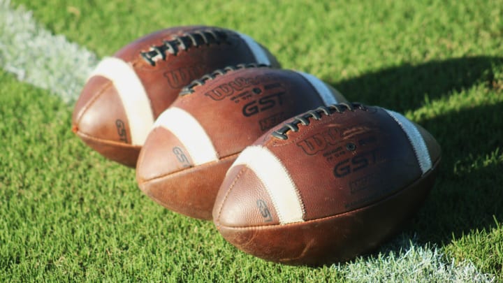 Footballs are displayed on the field before a high school football game