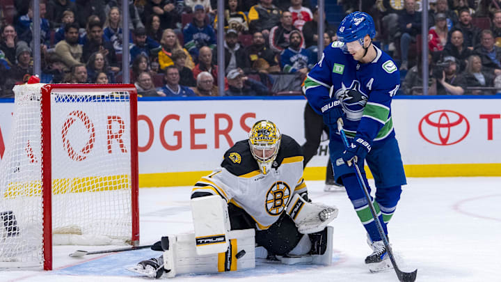 Dec 14, 2024; Vancouver, British Columbia, CAN; Boston Bruins goalie Jeremy Swayman (1) makes a save as Vancouver Canucks forward Elias Pettersson (40) looks for the rebound during the second period at Rogers Arena. Mandatory Credit: Bob Frid-Imagn Images