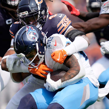 Tennessee Titans running back Tony Pollard (20) is wrapped up by Chicago Bears safety Jaquan Brisker (9) during the third quarter at Soldier Field in Chicago, Ill., Sunday, Sept. 8, 2024.