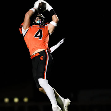 Solon wide receiver Maddox Kelley (4) makes a leaping catch Oct. 31, 2025 during a high school football round of 16 playoff game against the Benton Bobcats in Solon, Iowa.