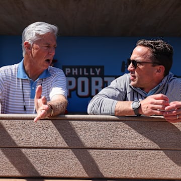Feb 25, 2024; Clearwater, Florida, USA;  Philadelphia Phillies president of baseball operations Dave Dombrowski and general manager Sam Fuld talk in the dugout before a game against the New York Yankees at BayCare Ballpark.