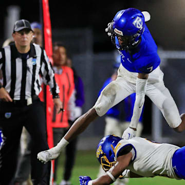 Trinity Christian's Tre Stewart (7) hurdles Orlando Christian Prep's Adryan Marayne (6) during the second quarter of an FHSAA Region 1-1M high school football playoff matchup Friday, Nov. 24, 2023 at Trinity Christian Academy in Jacksonville, Fla. [Corey Perrine/Florida Times-Union]