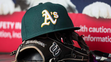Jun 1, 2024; Atlanta, Georgia, USA; A detailed view of an Oakland Athletics hat and glove on the field against the Atlanta Braves in the sixth inning at Truist Park. Mandatory Credit: Brett Davis-Imagn Images