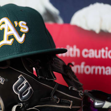 Jun 1, 2024; Atlanta, Georgia, USA; A detailed view of an Oakland Athletics hat and glove on the field against the Atlanta Braves in the sixth inning at Truist Park. Mandatory Credit: Brett Davis-Imagn Images