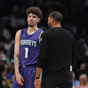 Mar 20, 2025; Charlotte, North Carolina, USA; Charlotte Hornets guard LaMelo Ball (1) talks with head coach Charles Lee  during a  free throw during the second half against the New York Knicks at Spectrum Center. Mandatory Credit: Jim Dedmon-Imagn Images