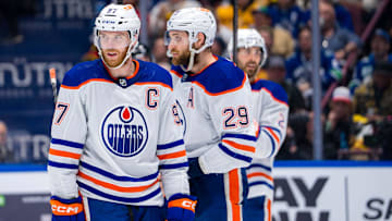 May 16, 2024; Vancouver, British Columbia, CAN; Edmonton Oilers forward Connor McDavid (97) and forward Leon Draisaitl (29) and defenseman Evan Bouchard (2) during a stop in play against the Vancouver Canucks during the first period in game five of the second round of the 2024 Stanley Cup Playoffs at Rogers Arena. Mandatory Credit: Bob Frid-Imagn Images
