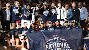 Allie Ziebell (front row second from left) and KK Arnold (front  row third from left) pose with teammates on the UConn women's basketball team after winning the NCAA Championship on Sunday. Mandatory Credit: Nathan Ray Seebeck-Imagn Images April 6, 2025; Tampa FL, USA