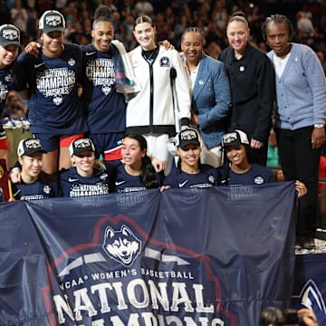 Allie Ziebell (front row second from left) and KK Arnold (front  row third from left) pose with teammates on the UConn women's basketball team after winning the NCAA Championship on Sunday. Mandatory Credit: Nathan Ray Seebeck-Imagn Images April 6, 2025; Tampa FL, USA
