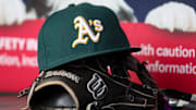 Jun 1, 2024; Atlanta, Georgia, USA; A detailed view of an Oakland Athletics hat and glove on the field against the Atlanta Braves in the sixth inning at Truist Park. Mandatory Credit: Brett Davis-Imagn Images