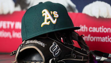 Jun 1, 2024; Atlanta, Georgia, USA; A detailed view of an Oakland Athletics hat and glove on the field against the Atlanta Braves in the sixth inning at Truist Park. Mandatory Credit: Brett Davis-Imagn Images