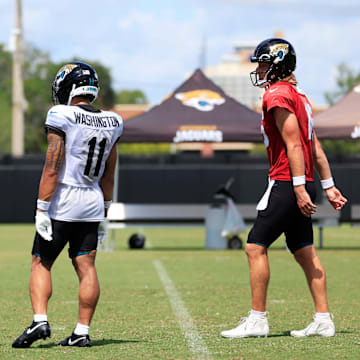 From left, Jacksonville Jaguars head coach Liam Coen, wide receiver Parker Washington (11) and quarterback Trevor Lawrence (16) talk after an NFL training camp session at the Miller Electric Center, Thursday, Aug. 14, 2025 in Jacksonville, Fla.