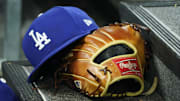Apr 28, 2024; Toronto, Ontario, CAN; A hat and glove of an Los Angeles Dodgers player durng a game against the Toronto Blue Jays at Rogers Centre. Mandatory Credit: John E. Sokolowski-Imagn Images