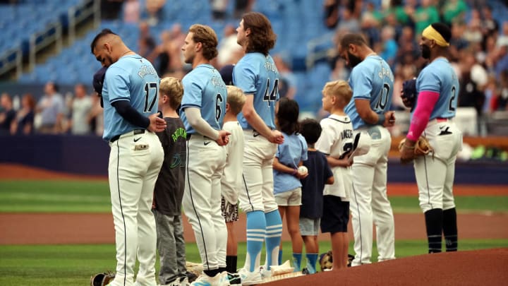 Jul 14, 2024; St. Petersburg, Florida, USA;  Tampa Bay Rays third base Isaac Paredes (17), shortstop Taylor Walls (6),  pitcher Ryan Pepiot (44), outfielder Amed Rosario (10) and first base Yandy Diaz (2) stand with kids during the national anthem against the Cleveland Guardians at Tropicana Field. Mandatory Credit: Kim Klement Neitzel-USA TODAY Sports