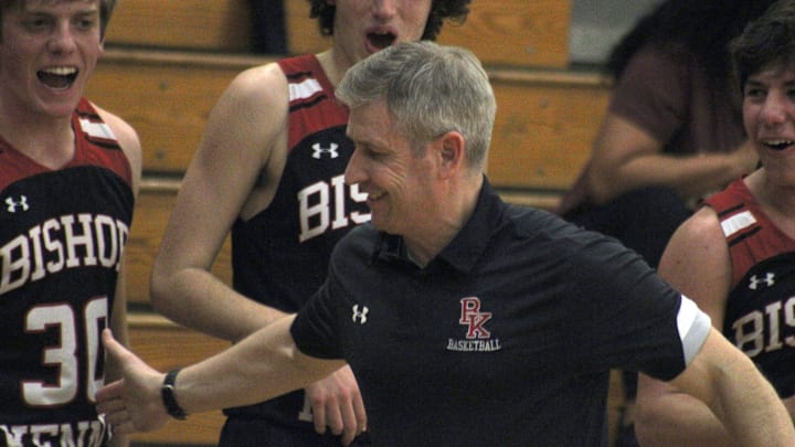 Bishop Kenny boys basketball head coach Jerry Buckley celebrates with players at the final whistle of an FHSAA Region 1-4A high school boys basketball semifinal at Paxon on February 21, 2023. [Clayton Freeman/Florida Times-Union]