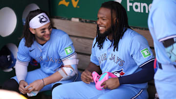 Jun 8, 2024; Oakland, California, USA; Toronto Blue Jays first baseman Vladimir Guerrero Jr. (27) sits next to shortstop Bo Bichette (11) before the start of the game against the Oakland Athletics at Oakland-Alameda County Coliseum. Mandatory Credit: Cary Edmondson-Imagn Images