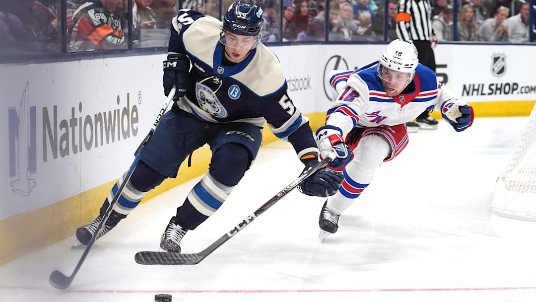 Blue Jackets forward Yegor Chinakhov plays the puck ahead of Rangers forward Vincent Trocheck.