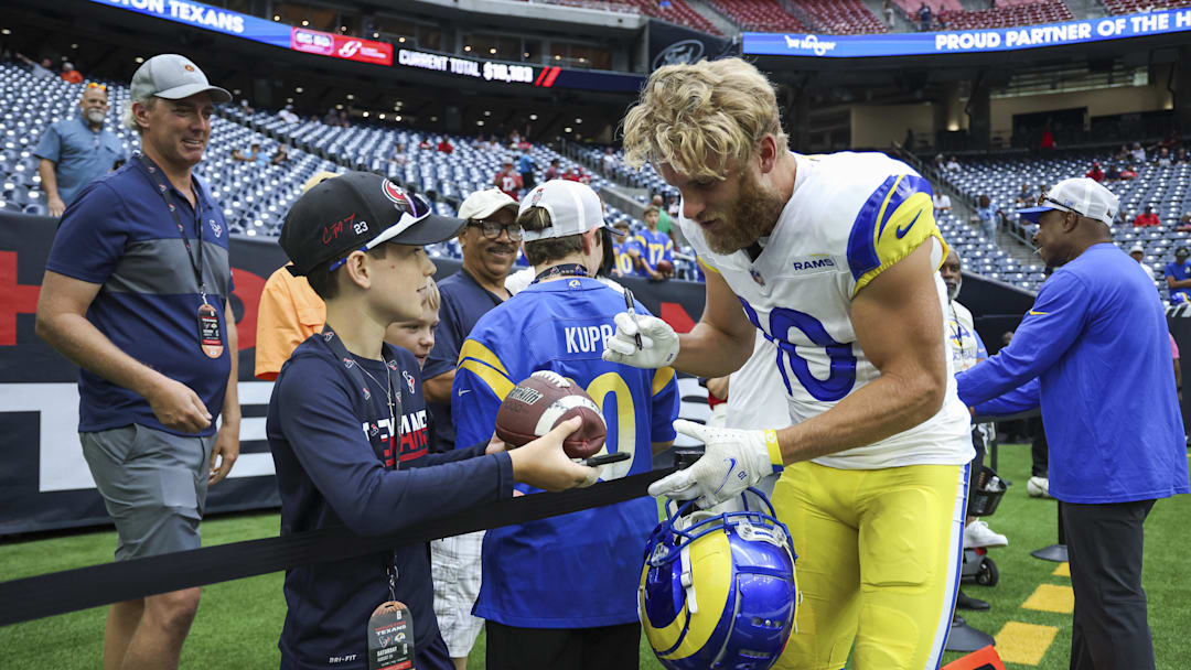 Aug 24, 2024; Houston, Texas, USA; Los Angeles Rams wide receiver Cooper Kupp (10) signs autographs before the game against the Houston Texans at NRG Stadium. Mandatory Credit: Troy Taormina-Imagn Images