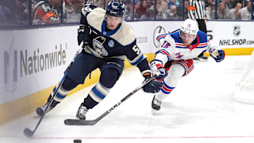 Blue Jackets forward Yegor Chinakhov plays the puck ahead of Rangers forward Vincent Trocheck.