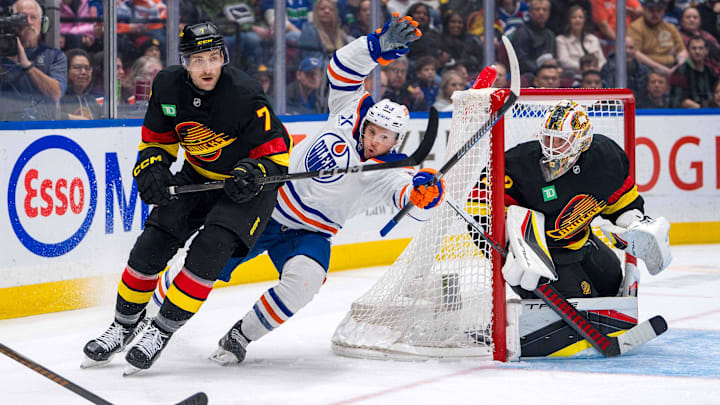 Vancouver Canucks goalie Kevin Lankinen (32) watches as defenseman Carson Soucy (7) battles with Edmonton Oilers forward Jeff Skinner (53) 