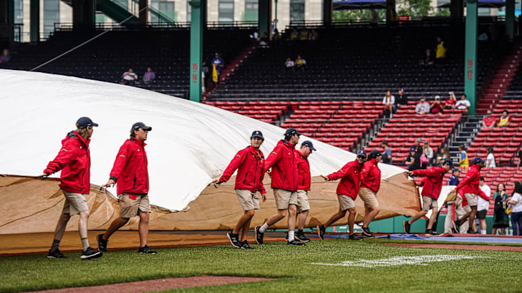 Jun 14, 2023; Boston, Massachusetts, USA; The Boston Red Sox field crew cover the field in