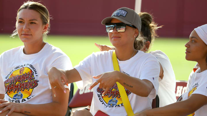 Oklahoma's Jayda Coleman, center, gives the horns down gesture as she sits beside Kinzie Hansen, left, and Rylie Boone (0) during a celebration of Oklahoma Sooners fourth consecutive softball national championship at Love's Field in Norman, Okla., Saturday, June 8, 2024.