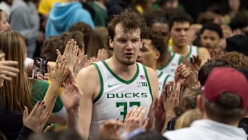 Oregon center Nate Bittle leads the Ducks through the student section after the game.